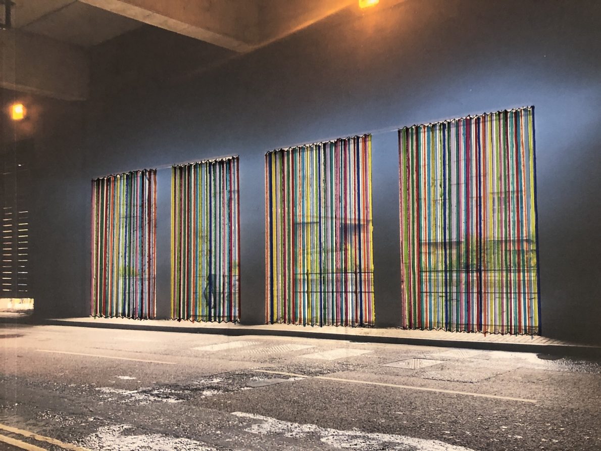 sketch of a rainbow of panels against a dark wall under a tunnel