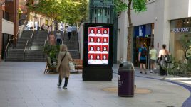 An image of a digital screen in a shopping centre showing the artwork ‘So... Where Are You Really From’ (2023) by Fiona McBennett.