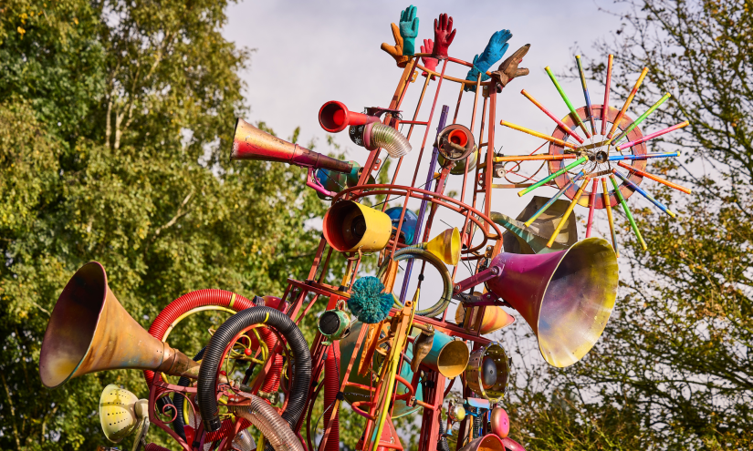 A close up of the tip of The Babylon Gamelan by Rag & Bone, created by artist Dave Young, 2024. Horns, gloves, bike wheels and all sorts of reclaimed and repainted junk are attached to the 4 metre tall structure. Photo by Andrew Moore