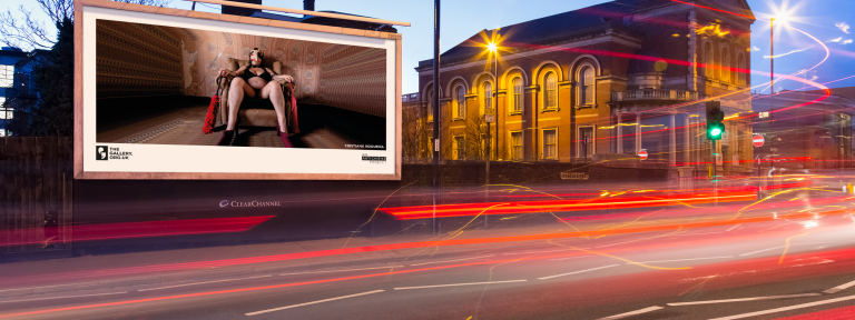 A roadside billboard at night showing the artwork; ‘The Kitchen Cupboard’ (2022), Frances Willoughby.