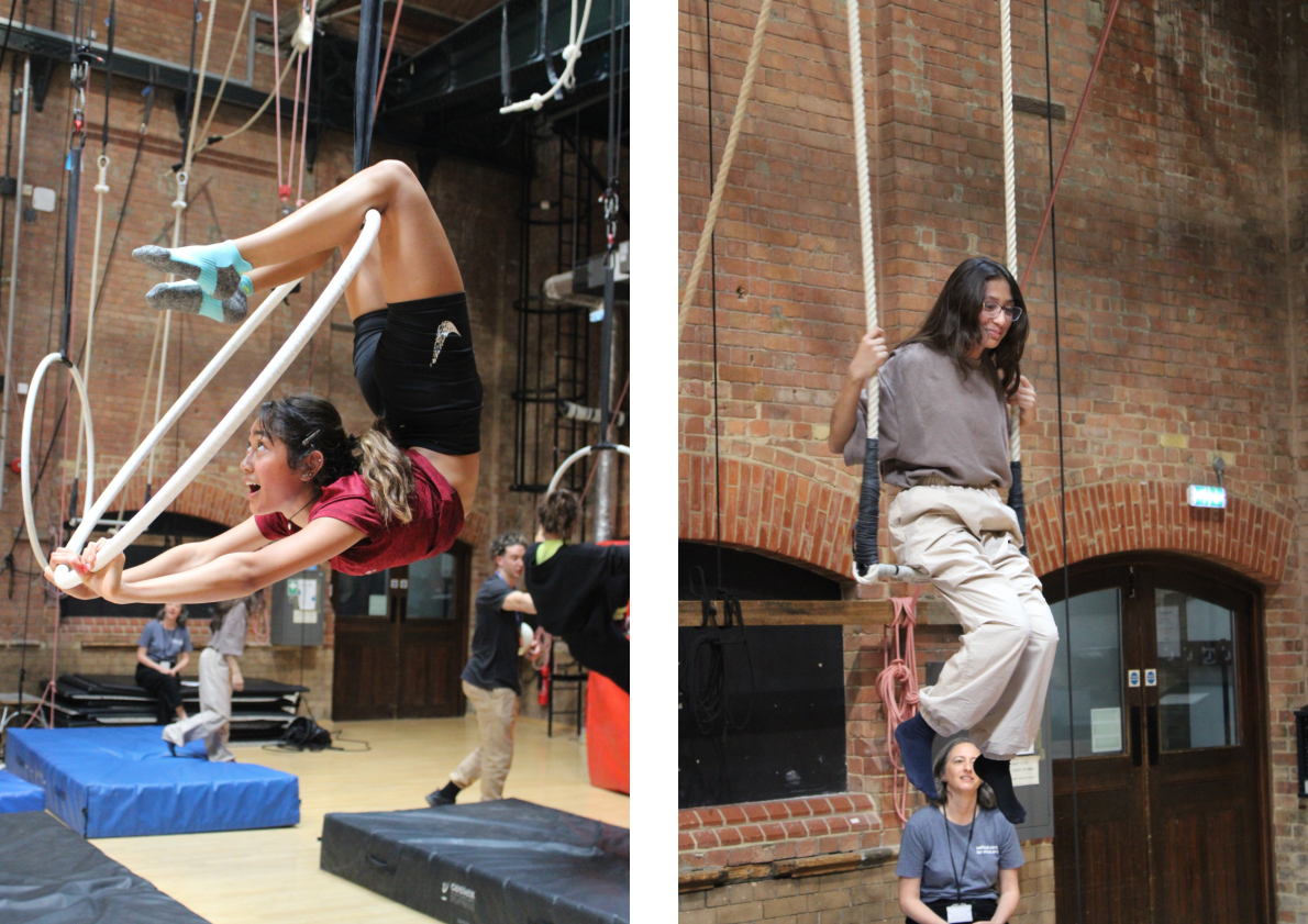 Two girls smiling as they do tricks on an aerial hoop.