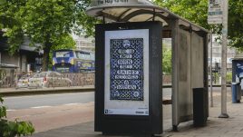 A busy city scene showing the artwork from The Gallery Season 4 on billboards. The artwork on display: Mosaic Art Nouveau tiles in Victorian blue & white with the quote 